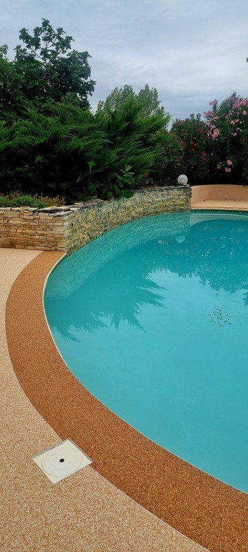 Réalisation d'une plage de piscine en Moquette de Pierre sur la commune de Paulhac en région Occitanie.