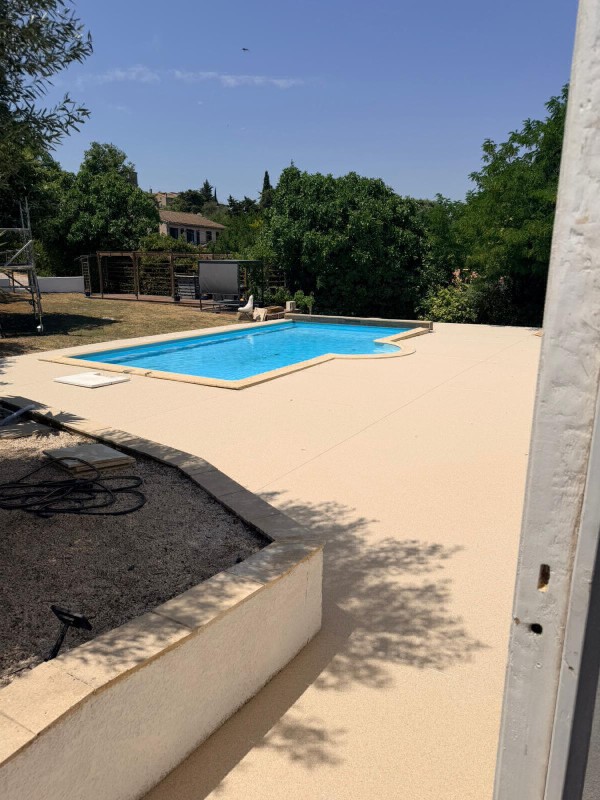 Réalisation d'un tour de piscine et des marches en moquette de pierre coloris Ivoire à Roullens, près de Carcassonne